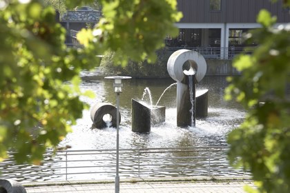 Albertslund Rådhus med rådhussøen og træer i forgrunden.